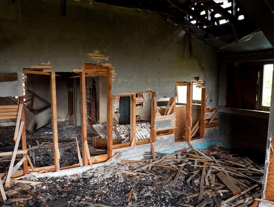 Interior of a home damaged by a fire with holes in the walls and roof
