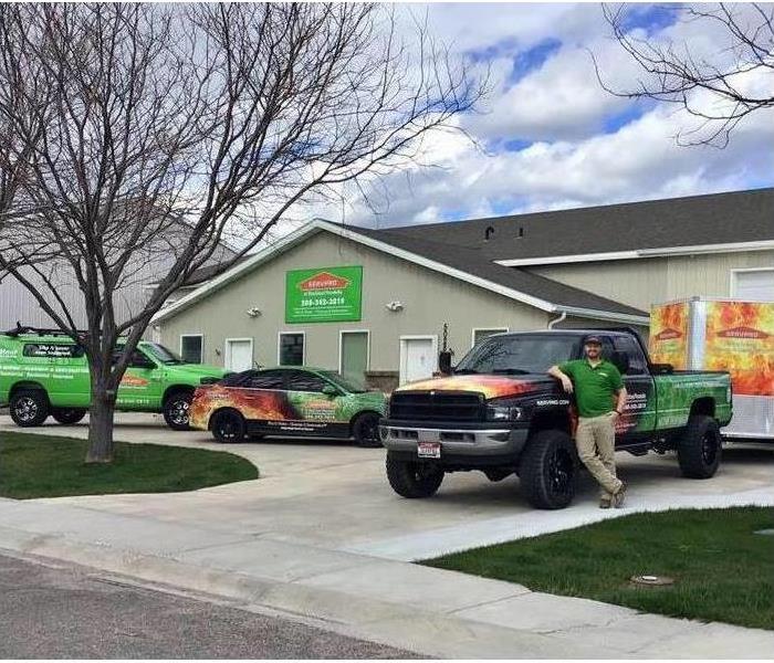 SERVPRO professional standing by a SERVPRO truck in front of local office. 